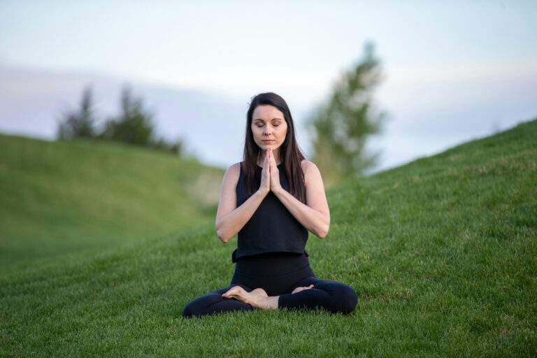 Woman Meditating on a Green Field